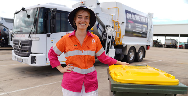 Resource Recovery Officer Amelia Chaplin in front of one of the six new Townsville City Council waste trucks fitted with pedestrian protection technology.