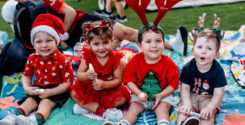 Ewan Rooskov, Olympia Nicopoulos, Leo Geisel and Harry Newman enjoying Council’s Carols By Candlelight event under the big top at Riverway Oval.