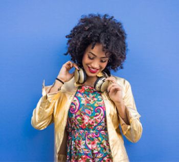 A woman smiling while listening to music on her headphones