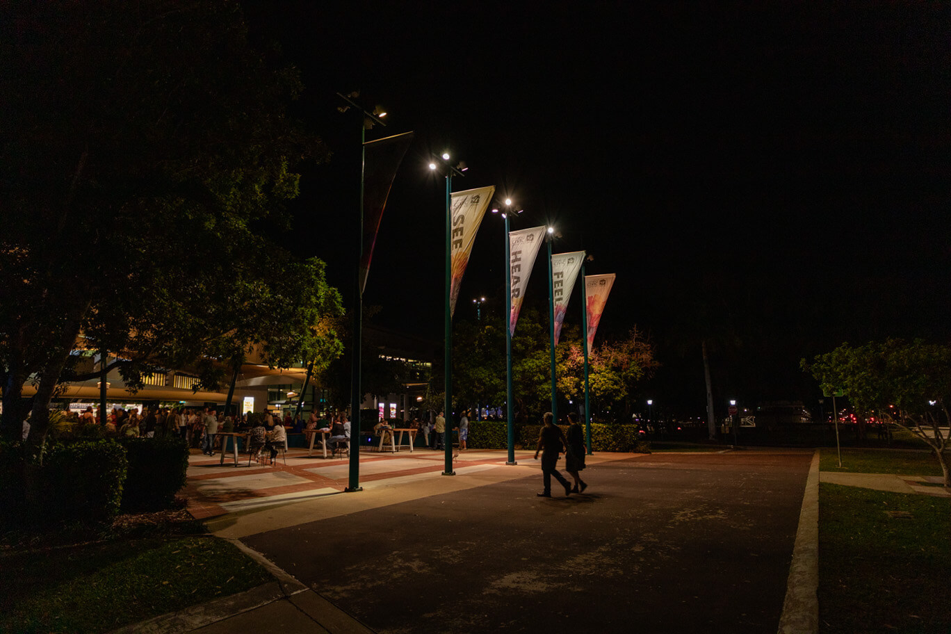People sitting at tables out front of Townsville Civic Theatre