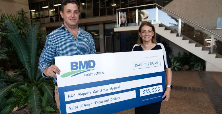 BMD Constructions regional construction manager Daniel Hussey presents Townsville Mayor Jenny Hill with a cheque for the Mayor's Christmas Appeal