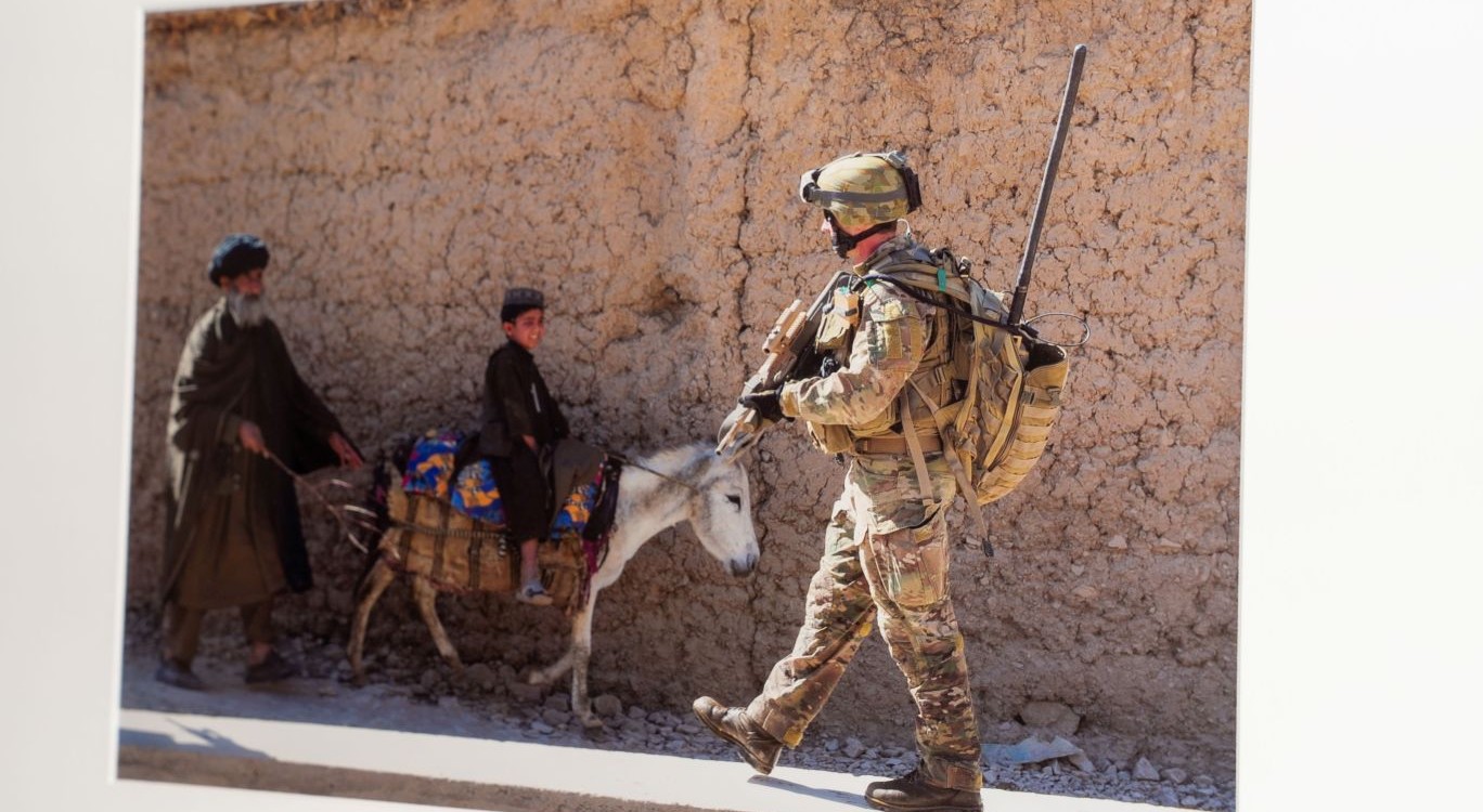 Evan Morgan’s photograph Troops from Delta Company 2RAR from Mirwais Forward Patrol Base patrol near Chora, Afghanistan. LT Chris Thompson-Lang, engineer troop commander Delta Company pass locals on the street.