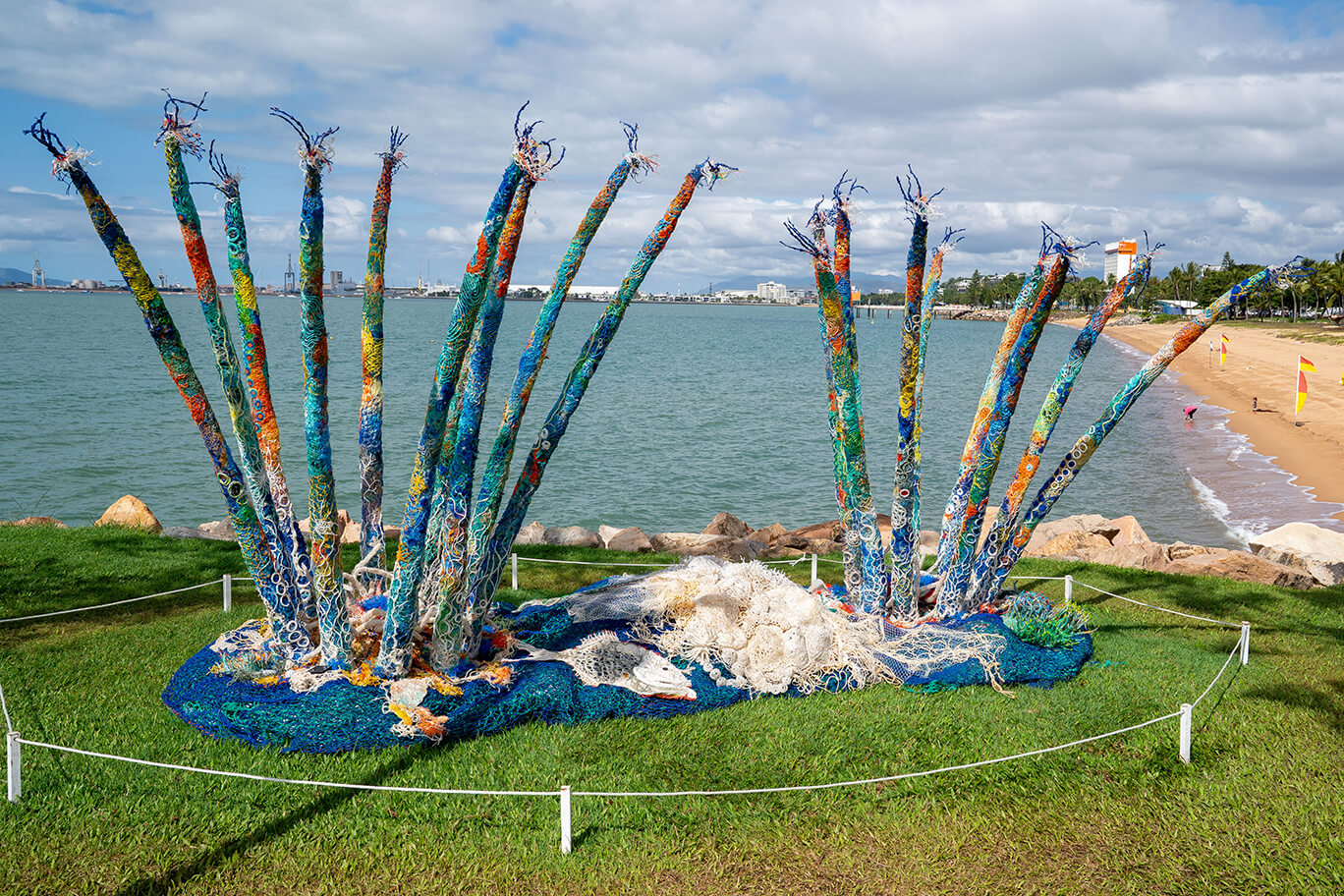 Anemones made of ghost net, beach found rope, sand, fabric, and fishing rod supports