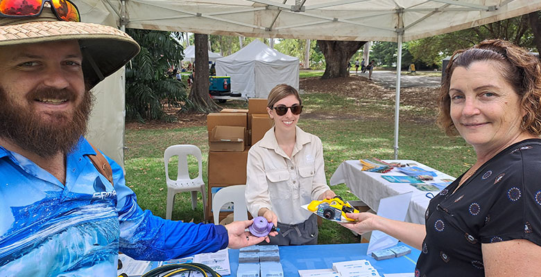 Annmarie from Council's Sustainability team (centre) helped Josh from Bushland Beach and Catherine from Rosslea swap an old sprinkler for a more efficient model at the Our Townsville Expo.