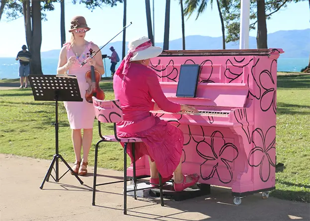 Women playing on a pink piano