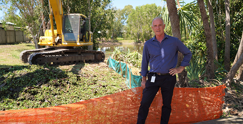 Community Health, Safety and Environmental Sustainability Committee chairperson Cr Maurie Soars with the excavator used to remove weeds from the basin