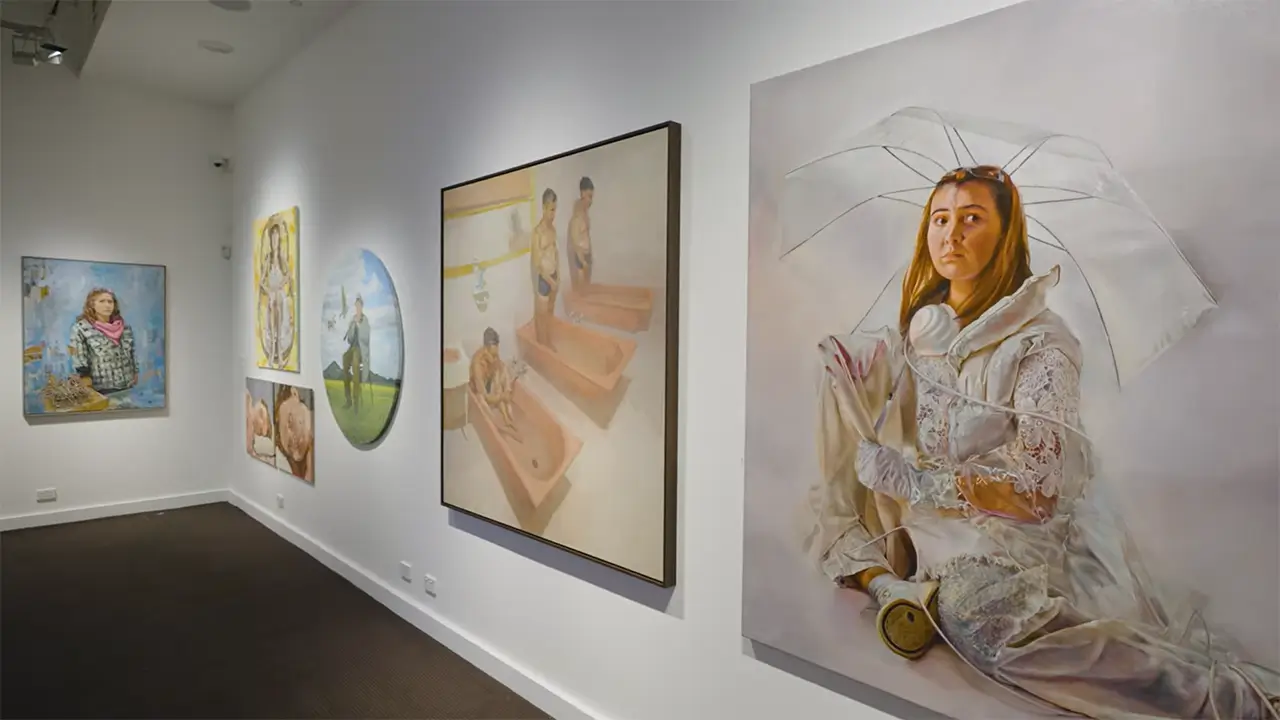 Gallery staff hanging animal portraits on the wall