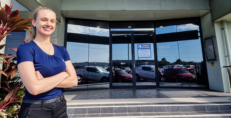 Chemical engineer Chelsea Burgess standing in front of the Townsville Water entrance