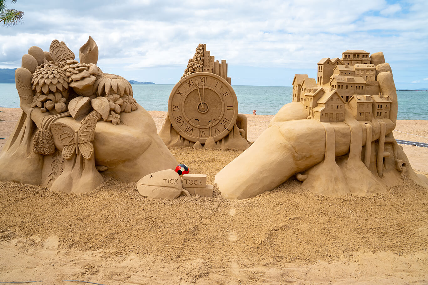Sand sculpture of a clock with the time a few minutes from midnight