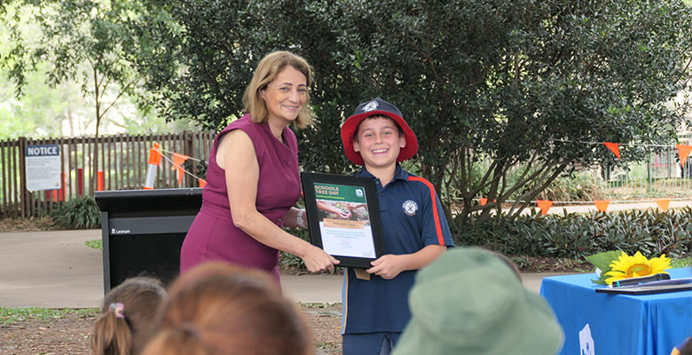Mayor Jenny Hill handing a certificate to Ryan Catholic College student Charlie Mibus for his school’s involvement in Schools Tree Day