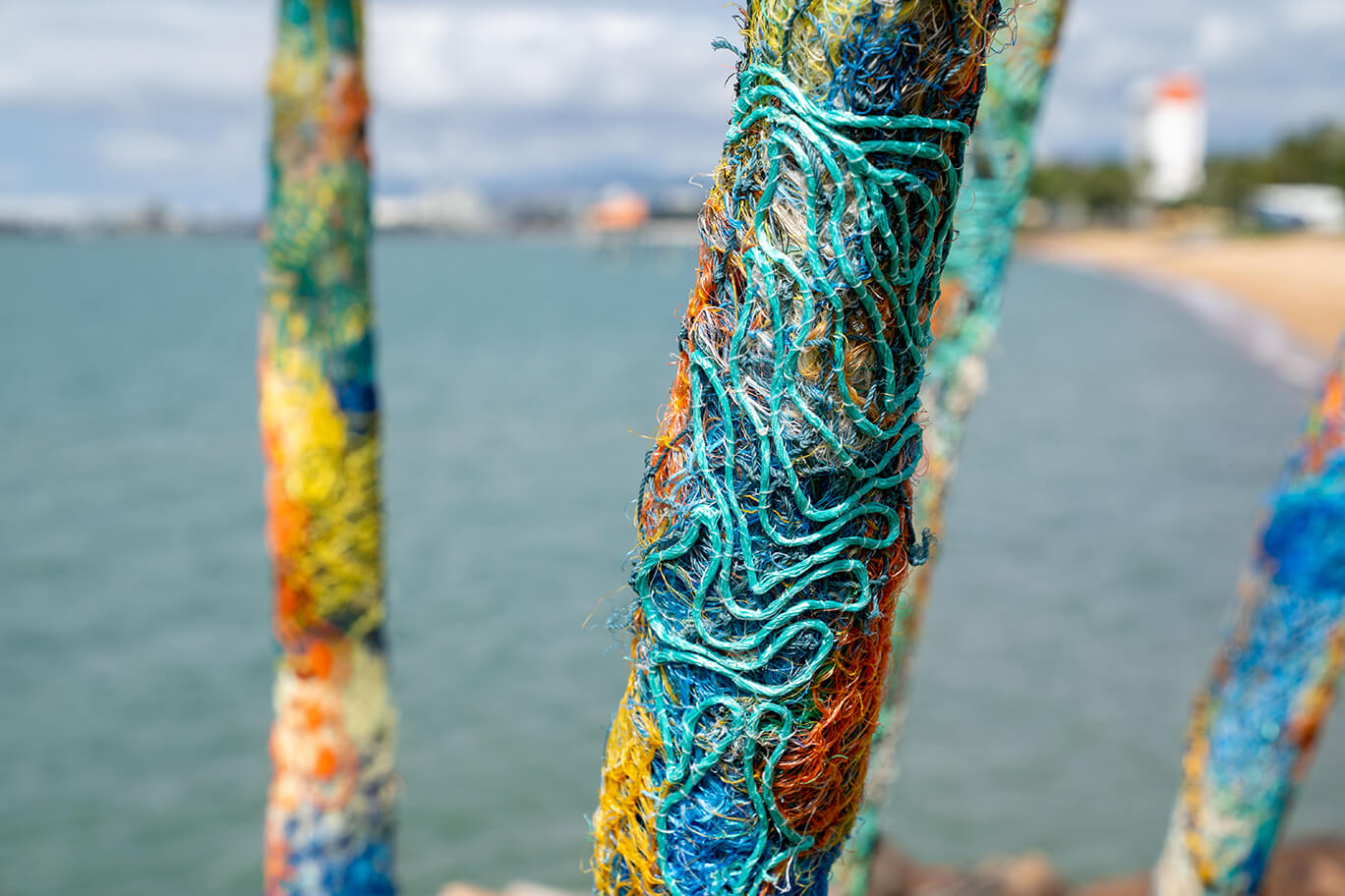 Anemones made of ghost net, beach found rope, sand, fabric, and fishing rod supports