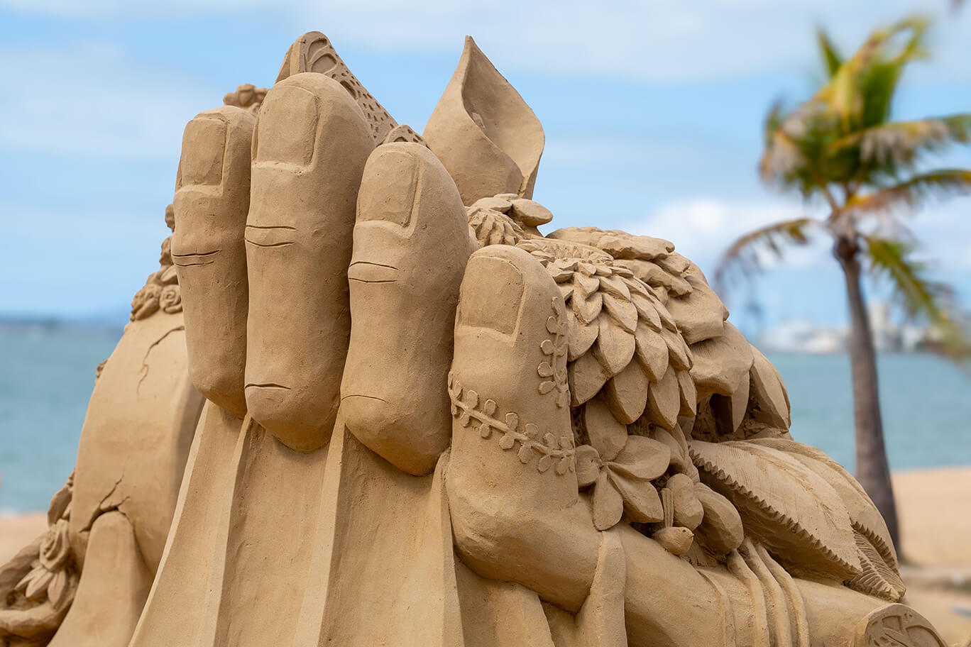 Sand sculpture of leaves and flowers in a hand