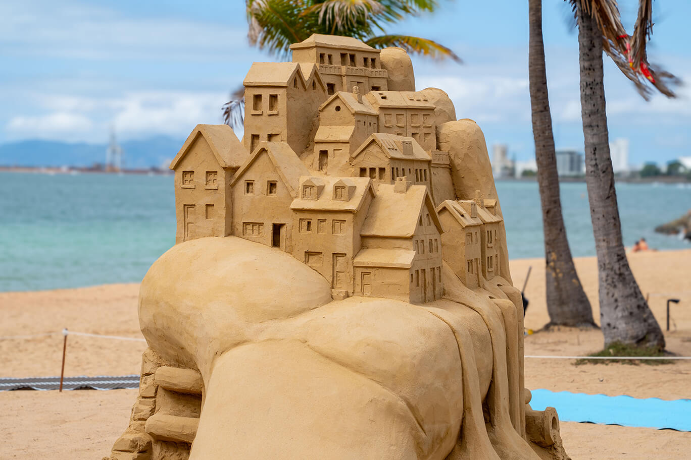 Sand sculpture of houses in another hand