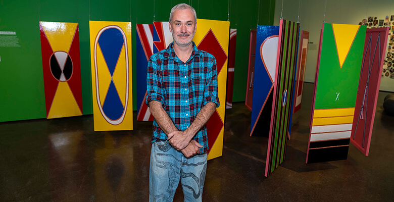 Curator Bradley Vincent inside the Leagues exhibition at Pinnacles Gallery