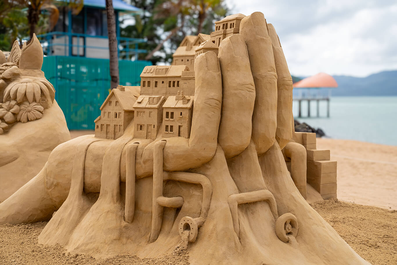 Sand sculpture of pollution coming out of houses