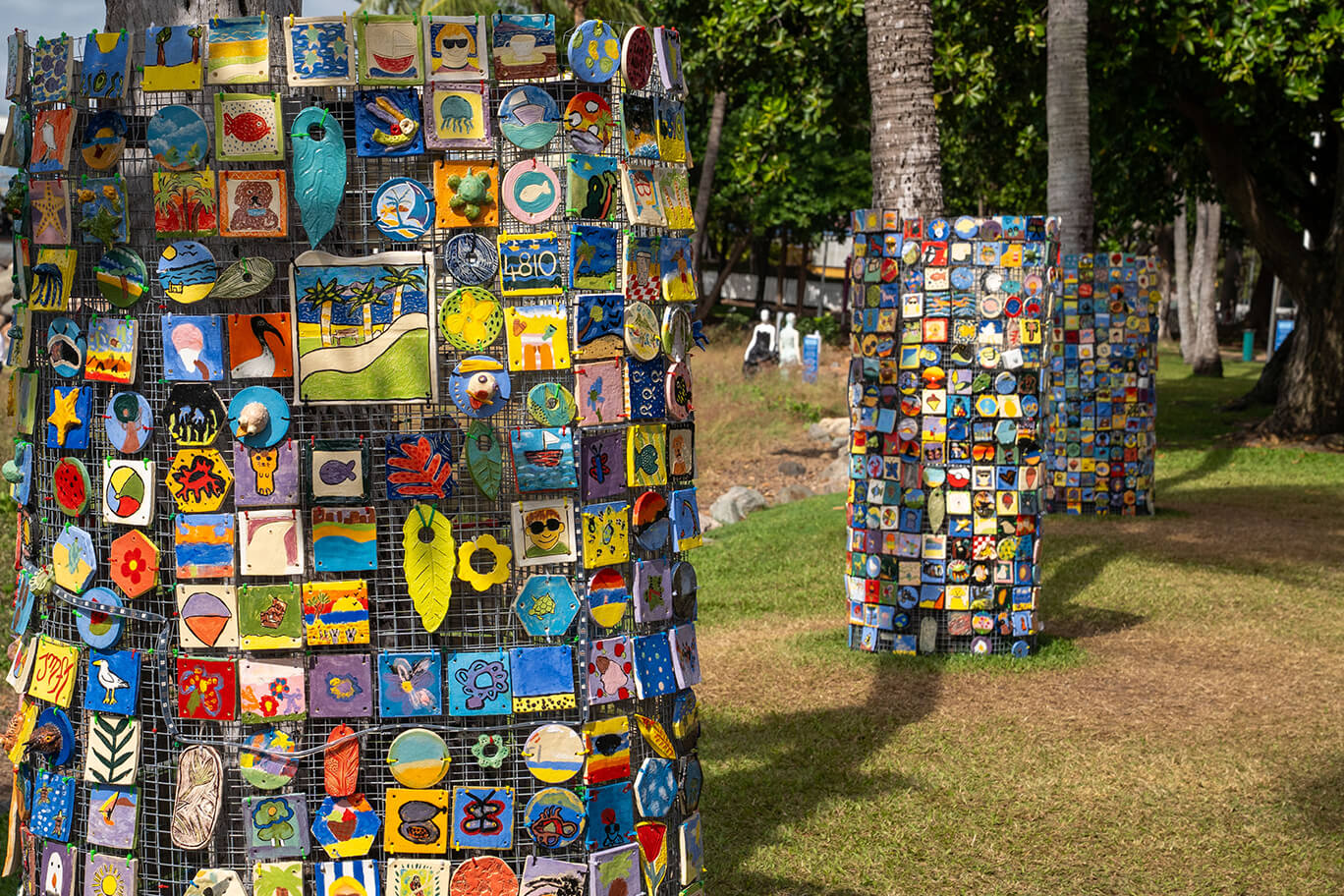 Totem poles covered in ceramic tiles with various beach images