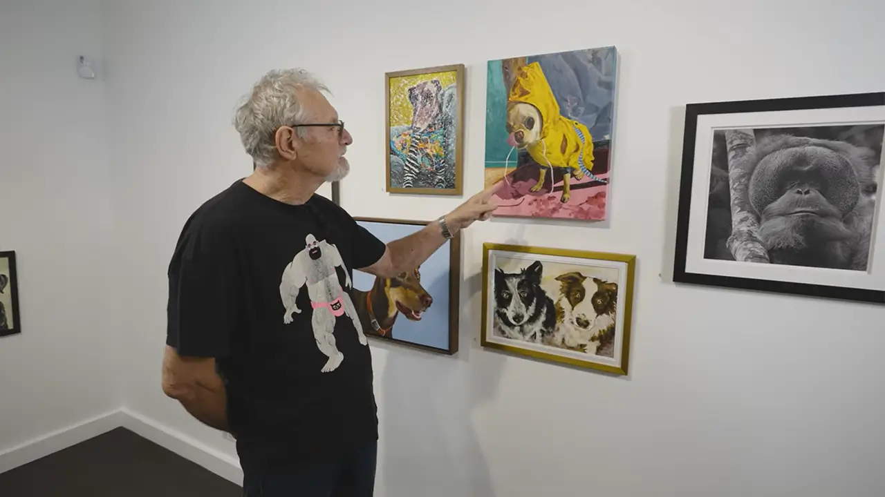 Ron McBurnie pointing at Eye on the Weather by Catherine Stewart