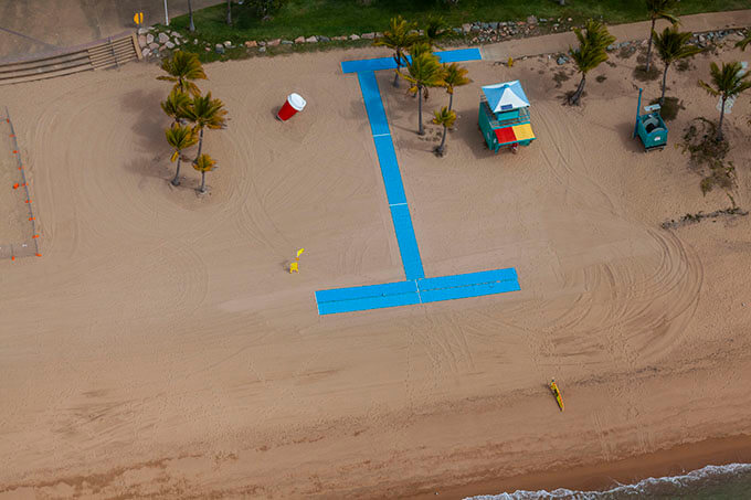 Aeriel photograph shows beach access mats leading from a concrete ramp to the hard sand at The Strand